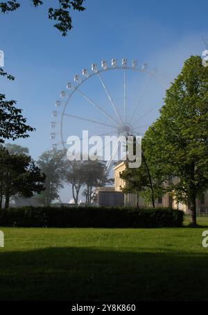 Kuehlungsborn, Allemagne - 30 mai 2021 : grande roue blanche derrière les arbres et les plantes un soir de printemps avec un léger brouillard sur la côte Baltique dans le nord du G Banque D'Images