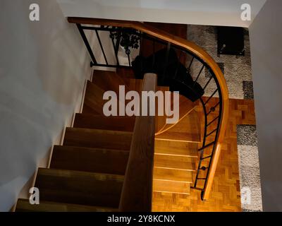 Escaliers courbes en bois, une partie de l'intérieur de la maison. Lumineux et sombre. Monter ou descendre Banque D'Images