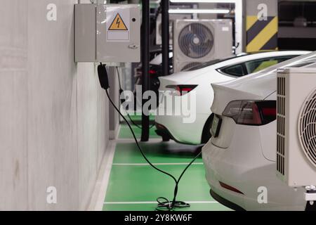 Poznan, Grande Pologne Voïvodie, Pologne, 09.26.2024 voitures électriques se chargeant dans le parking souterrain Banque D'Images