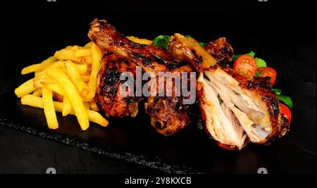 Ailes de poulet grillées avec frites et laitue d'agneau et garniture de citron Banque D'Images