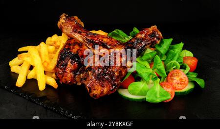 Ailes de poulet grillées avec frites et laitue d'agneau et garniture de citron Banque D'Images