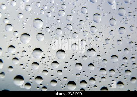 Vue de dessus des gouttelettes d'eau de pluie sur plastique transparent. Concept de pluie fraîche. Banque D'Images