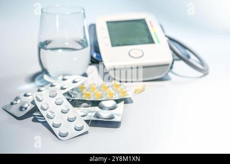 Beaucoup de pilules, comprimés et gélules dans des emballages blister avec un verre d'eau et un tensiomètre, médecine et concept de soins de santé, espace de copie, se Banque D'Images