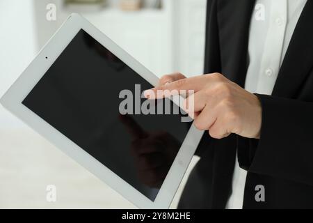 Femme d'affaires utilisant la tablette à l'intérieur, gros plan. Technologie moderne Banque D'Images