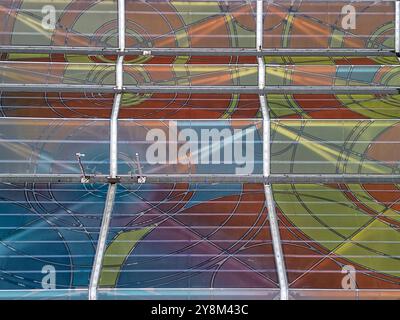 Station de tramway moderne à Łódź, en Pologne, avec des tramways vibrants et un toit en auvent coloré dans un cadre urbain animé par une journée nuageuse Banque D'Images