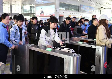 YANTAI, CHINE - 6 OCTOBRE 2024 - les passagers entrent par la porte d'embarquement à la gare ferroviaire de Yantai, dans la province du Shandong de l'est de la Chine, le 6 octobre 2024. Banque D'Images