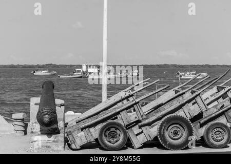 Un vieux canon avec chariot poussant garé sur le côté face à l'île de Manda à Lamu Banque D'Images