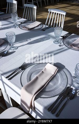 Verre de cristal sur la table dans une salle de banquet lumineuse aux parois de verre. Photo prise pendant la journée, avec la lumière du soleil. Banque D'Images