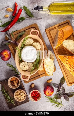 Ingrédients pour un délicieux camembert cuit au four entouré d'herbes fraîches, d'épices et de noix sur un fond clair Banque D'Images