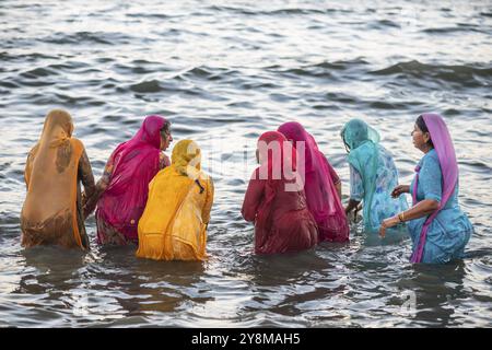 Pèlerins hindous, femme en saris colorés, prendre un bain sacré dans la mer devant le lever du soleil à Ghat Agni Theertham, Rameswaram ou Rameshwaram, île de Pamban Banque D'Images