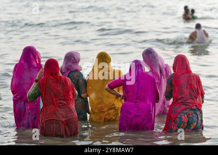 Pèlerins hindous, femme en saris colorés, prendre un bain sacré dans la mer devant le lever du soleil à Ghat Agni Theertham, Rameswaram ou Rameshwaram, île de Pamban Banque D'Images