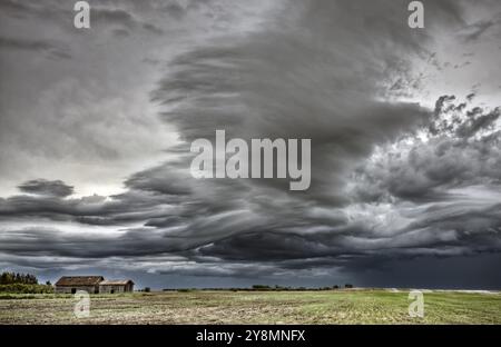 Ferme abandonnée avec les nuages de tempête dans les Prairies canadiennes Banque D'Images