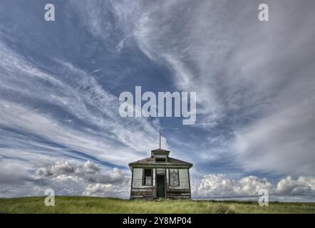 Ferme abandonnée avec les nuages de tempête dans les Prairies canadiennes Banque D'Images