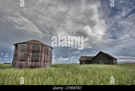 Ferme abandonnée avec les nuages de tempête dans les Prairies canadiennes Banque D'Images