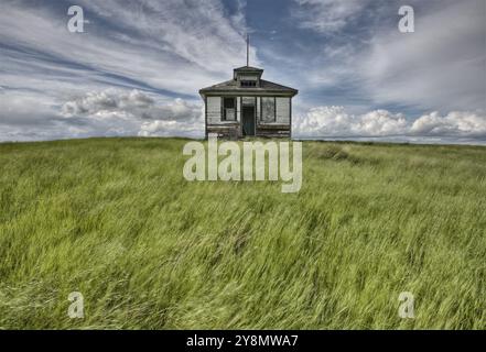 Ferme abandonnée avec les nuages de tempête dans les Prairies canadiennes Banque D'Images