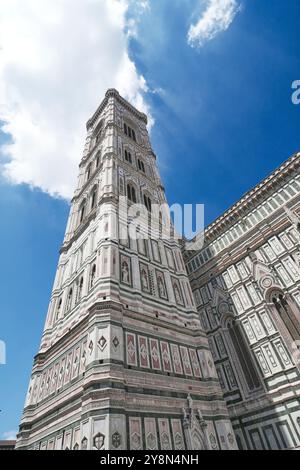 Une vue basse dramatique regardant vers le haut de la majestueuse tour campanarie de Giotto revêtue de panneaux de marbre géométriques à la cathédrale de Florence, en Italie. Banque D'Images