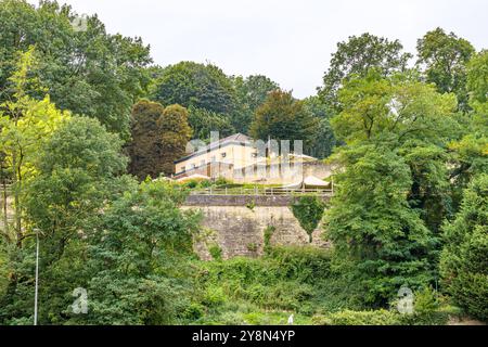 Terrasse et bâtiment sur la colline entouré d'arbres verdoyants abondants contre le ciel gris, mur jaune Marne, jour nuageux à Maastricht, Limbourg Sud, Net Banque D'Images