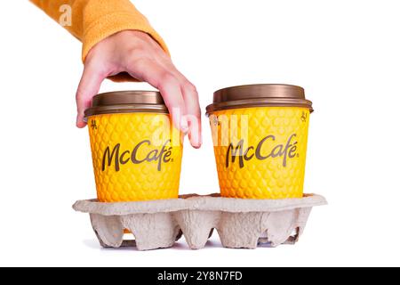 Kiev, Ukraine - 24 septembre 2024 : main tendue pour deux tasses à café McCafé dans un emballage jaune sur un support en carton, idéal pour le café et le style de vie Banque D'Images