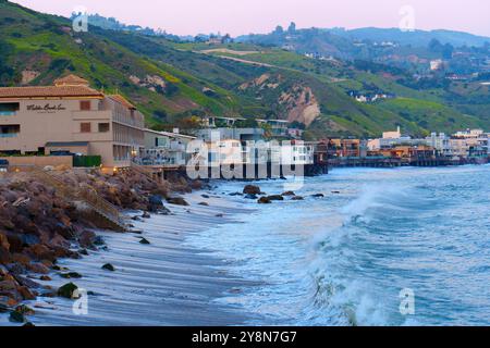 Malibu, Californie - 21 avril 2024 : charmant littoral de Malibu avec des maisons le long du rivage et des collines verdoyantes. Banque D'Images