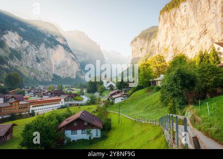 Vue panoramique de Lauterbrunnen village montagneux traditionnel avec la célèbre église et les chutes de Staubbach à Lauterbrunnen le matin au Canton de Berne, SW Banque D'Images