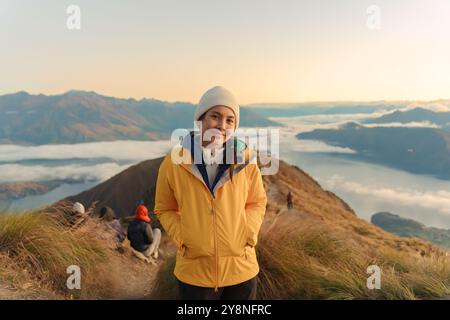 Réalisation femme touriste debout sur la montagne au sommet de Roys Peak avec brume entre Wanaka et Glendhu Bay dans la matinée à la Nouvelle-Zélande Banque D'Images