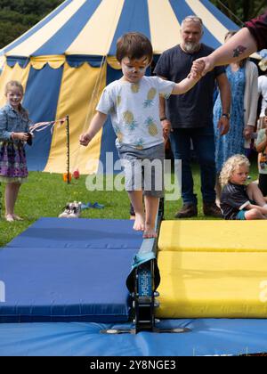 Un jeune enfant apprend à marcher sur la corde raide lors d'un atelier sur les compétences du cirque, Bude, Cornwall, Royaume-Uni Banque D'Images