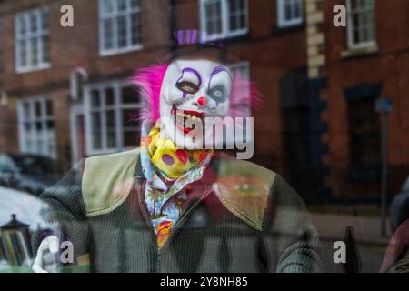 Entrez dans le charme sinistre de cette vitrine, où un clown effrayant vous attend ! Banque D'Images