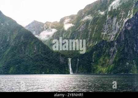 Naviguez le long du fjord et admirez la vue sur la montagne avec la cascade qui coule et le brouillard dans le Milford Sound, dans le parc national de Fiordland, en Nouvelle-Zélande Banque D'Images