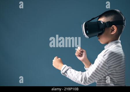 Contexte, un garçon joue à un jeu éducatif de RV, démontrant comment la technologie peut améliorer les expériences d'apprentissage pour les enfants. enfant, vidéo de jeu vr, garçon, e Banque D'Images