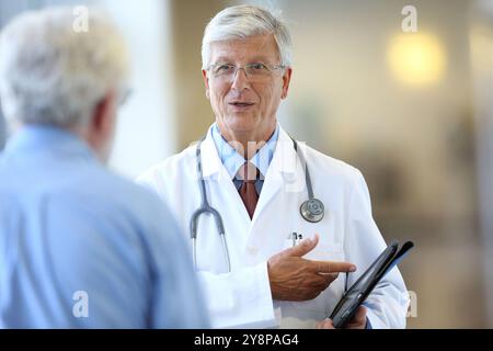 Médecin avec stéthoscope et tablette parlant avec le patient, Hôpital Onkologikoa, Institut d'oncologie, Centre de cas pour la prévention, le diagnostic et le traitement du cancer, Donostia, Saint-Sébastien, Gipuzkoa, pays Basque, Espagne. Banque D'Images