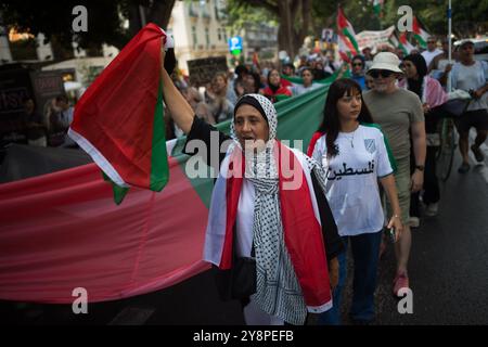 Malaga, Espagne. 06 octobre 2024. Un manifestant tient un drapeau palestinien lors d'une manifestation mondiale contre le génocide en Palestine suite à l'escalade du conflit au moyen-Orient. La veille de l’anniversaire des attentats du 7 octobre et du début de la guerre entre Israël et le Hamas, des milliers de personnes descendent dans les rues de la ville de Malaga en solidarité avec le Liban et la Palestine pour exiger la fin du commerce des armes avec Israël et de l’occupation militaire israélienne en Palestine. Crédit : SOPA images Limited/Alamy Live News Banque D'Images