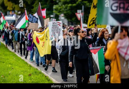 Stuttgart, Allemagne. 06 octobre 2024. Les participants à une manifestation pro-palestinienne traversent le centre-ville avec des drapeaux et des banderoles pendant le contre-événement à un rassemblement pro-israélien. Crédit : Christoph Schmidt/dpa/Alamy Live News Banque D'Images