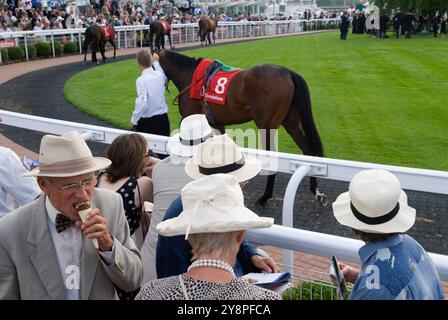 Homme plus âgé mangeant de la crème glacée l'anneau de parade, les gens portant des chapeaux de paille d'été. Epsom Derby Day Horse Racing. Epsom Downs, Surrey, Angleterre des années 2007 2000 Royaume-Uni HOMER SYKES Banque D'Images