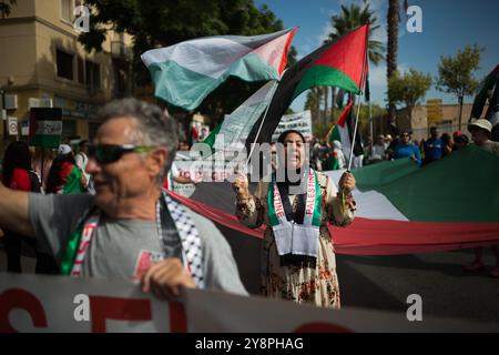 Malaga, Espagne. 06 octobre 2024. Un manifestant agite un drapeau palestinien lors d'une manifestation mondiale contre le génocide en Palestine suite à l'escalade du conflit au moyen-Orient. La veille de l’anniversaire des attentats du 7 octobre et du début de la guerre entre Israël et le Hamas, des milliers de personnes descendent dans les rues de la ville de Malaga en solidarité avec le Liban et la Palestine pour exiger la fin du commerce des armes avec Israël et de l’occupation militaire israélienne en Palestine. (Photo de Jesus Merida/SOPA images/SIPA USA) crédit : SIPA USA/Alamy Live News Banque D'Images