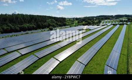 Cette vue aérienne époustouflante capture un vaste champ solaire, mettant en valeur une vaste gamme de panneaux solaires exploitant l'énergie du soleil. La grille ordonnée reposait Banque D'Images