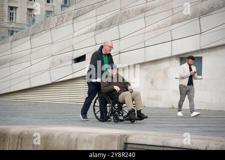 Vieil homme poussé dans un fauteuil roulant Banque D'Images