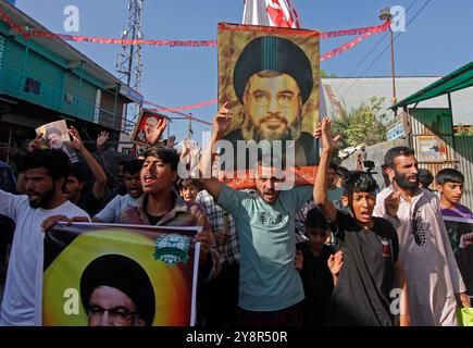 Pattan, Cachemire, Inde. 6 octobre 2024. les musulmans chiites du Cachemire portent des photos du dirigeant du Hezbollah Hassan Nasralla et crient des slogans anti-Israël alors qu'ils prennent part à une manifestation pour montrer leur colère contre le meurtre du dirigeant du Hezbollah Hassan Nasrallah. Nasrallah a été tué dans la banlieue sud de Beyrouth, au Liban, par une frappe aérienne israélienne. Banque D'Images