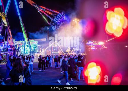 Stuttgart, Allemagne. 06 octobre 2024. Le 177ème Cannstatter Volksfest sur le Cannstatter Wasen est illuminé de couleurs dans la soirée. Le 'Wasen' est le deuxième plus grand festival folklorique en Allemagne après l'Oktoberfest de Munich. Crédit : Christoph Schmidt/dpa/Alamy Live News Banque D'Images