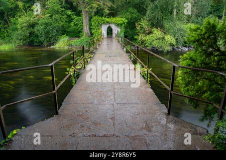 Pont de pierre menant à la pittoresque maison de pêche des moines à l'abbaye de Cong Banque D'Images