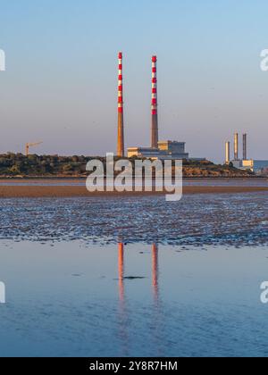 Les cheminées Poolbeg se reflétaient sur Sandymount Strand à l'heure d'or avec leur nouvelle couche de peinture Banque D'Images