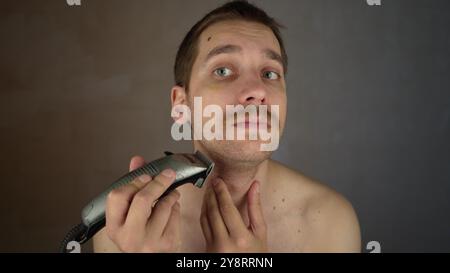 rasoir électrique pour le rasage du visage. coupez la barbe de 3 jours avec un rasoir. procédé de rasage de barbe pour homme de 3 jours. gars non rasé. garniture de barbe. homme rasant le visage en gros plan. man Banque D'Images