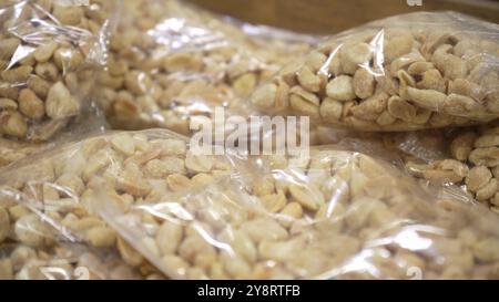 Arachis à l'intérieur du plastique emballé dans une épicerie. Emballage de différents types de noix sur la fenêtre. Grand plan, collation, concept de sain Banque D'Images