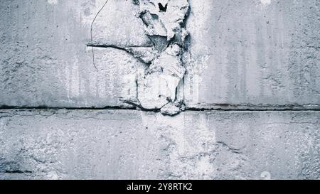 Une fissure dans le mur d'argile blanche d'une vieille maison. Mouvement de la caméra en gros plan le long de la fissure. Perte d'intégrité du bâtiment Banque D'Images