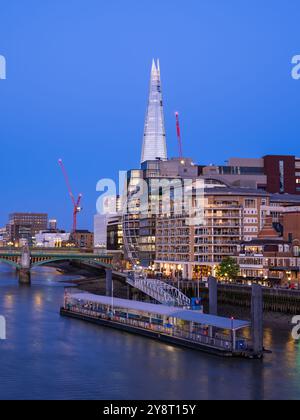 Londres, Royaume-Uni - 25 juin 2024 : un paysage urbain dynamique de Londres avec des gratte-ciel modernes le long de la Tamise, heure bleue. Banque D'Images