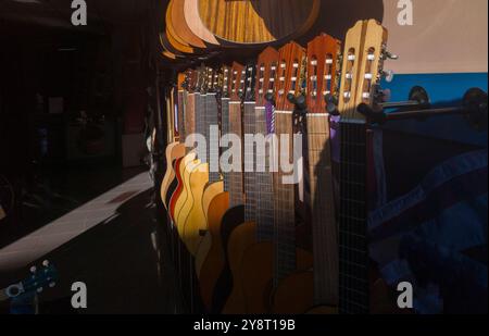 Boutique de guitares espagnoles. Rayons du soleil éclairant partiellement les guitares Banque D'Images