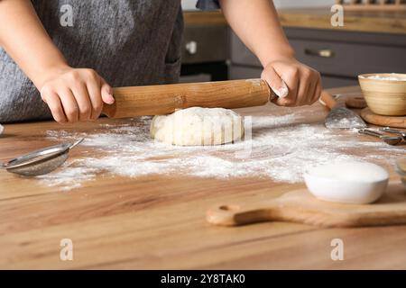 Femme préparant des rouleaux traditionnels à la cannelle dans la cuisine Banque D'Images