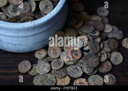 Beaucoup de pièces de monnaie romaines sur la vieille table en bois sombre, ancien trésor d'argent, fond vintage. Concept de pile, antique, Empire, texture, civilisation et histoire Banque D'Images