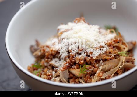 Bouillie de sarrasin servie avec des champignons et du fromage dans un bol Banque D'Images