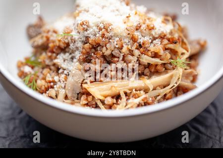 Bouillie de sarrasin avec champignons, oignons et herbes servies dans un bol Banque D'Images