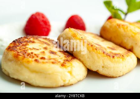 Crêpes au fromage cottage avec framboises couchées sur une assiette blanche Banque D'Images